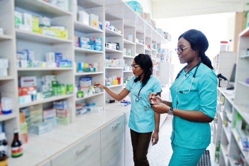 Two female African American pharmacists working behind the drugstore counter