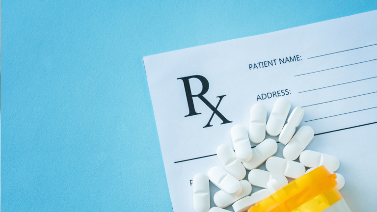 Antibiotic prescribing- Antibiotics spilled over a prescription pad.