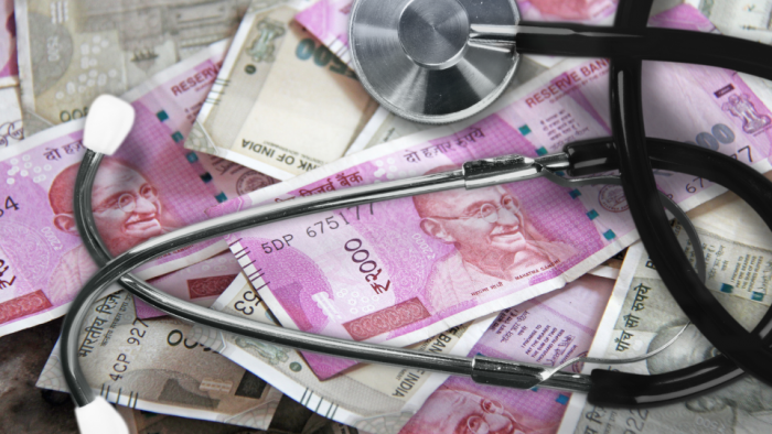 Stethoscope over rupees