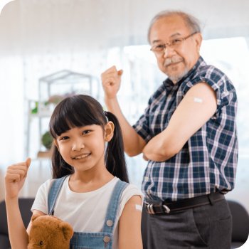 An Asian child and older adult man showing off post-vaccine band-aids.