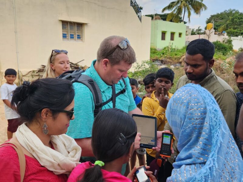 Christopher is showing enumerators how air quality monitor readings should be documented.