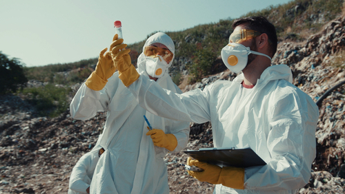 People in bacteriological gear taking samples in dry outdoor environment
